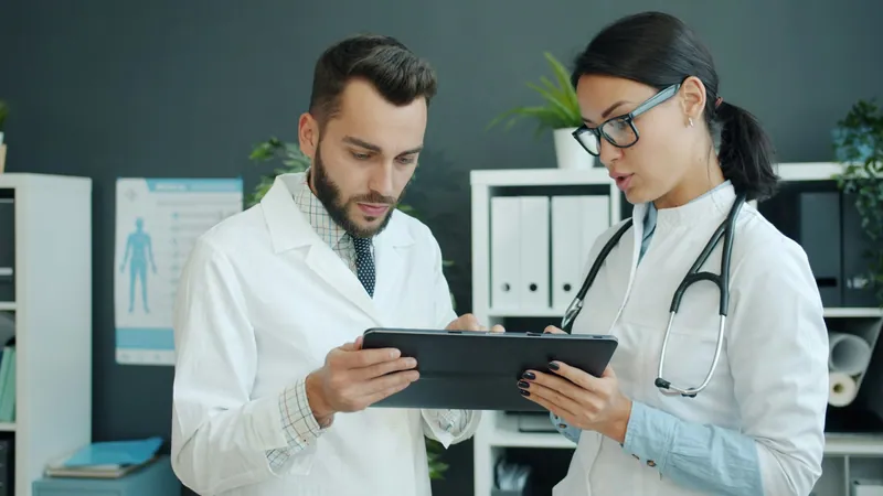 Two doctors reviewing patient information on a tablet