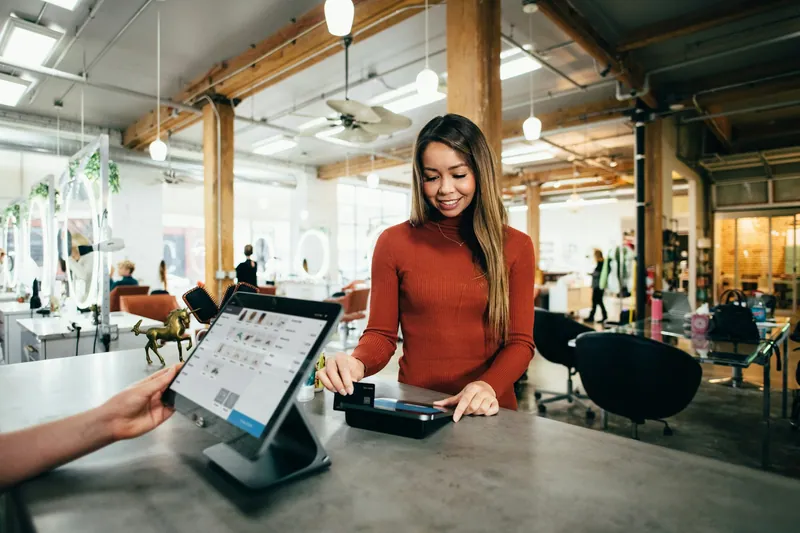 A shopper paying by card at a store checkout