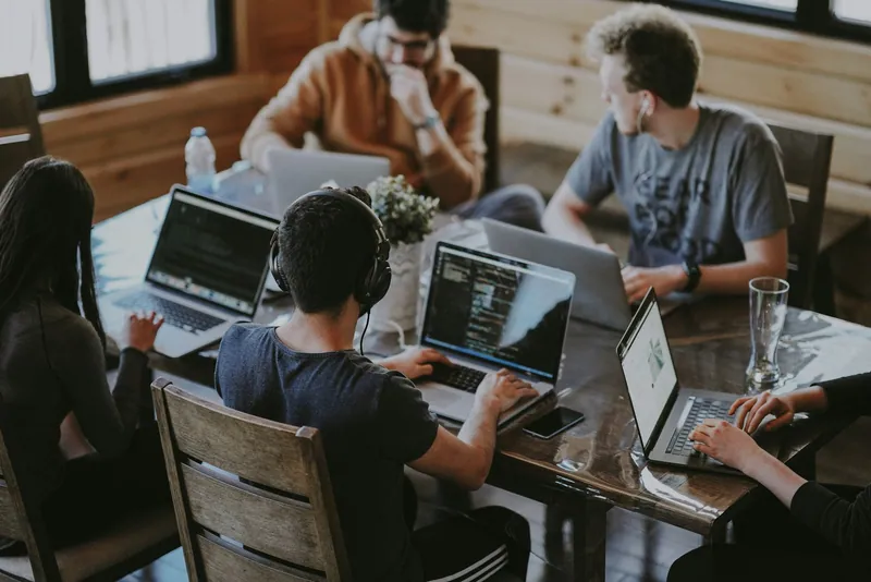 A product team writing code together at a shared table