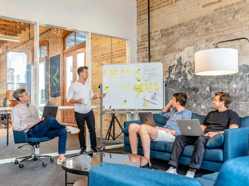 A team working through a plan on a whiteboard in a workshop